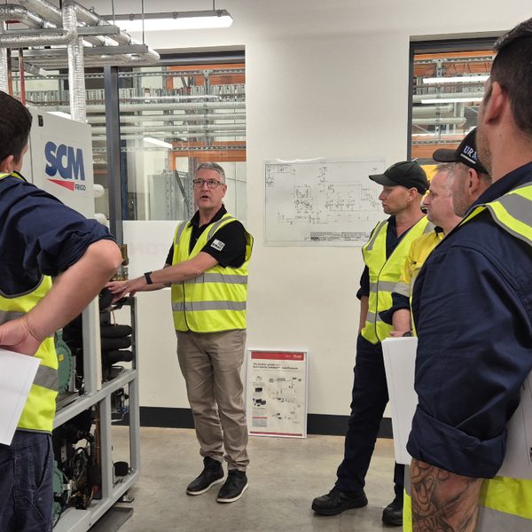 Technicians in high-visibility vests training on a CO₂ rack at the Beijer Ref Academy